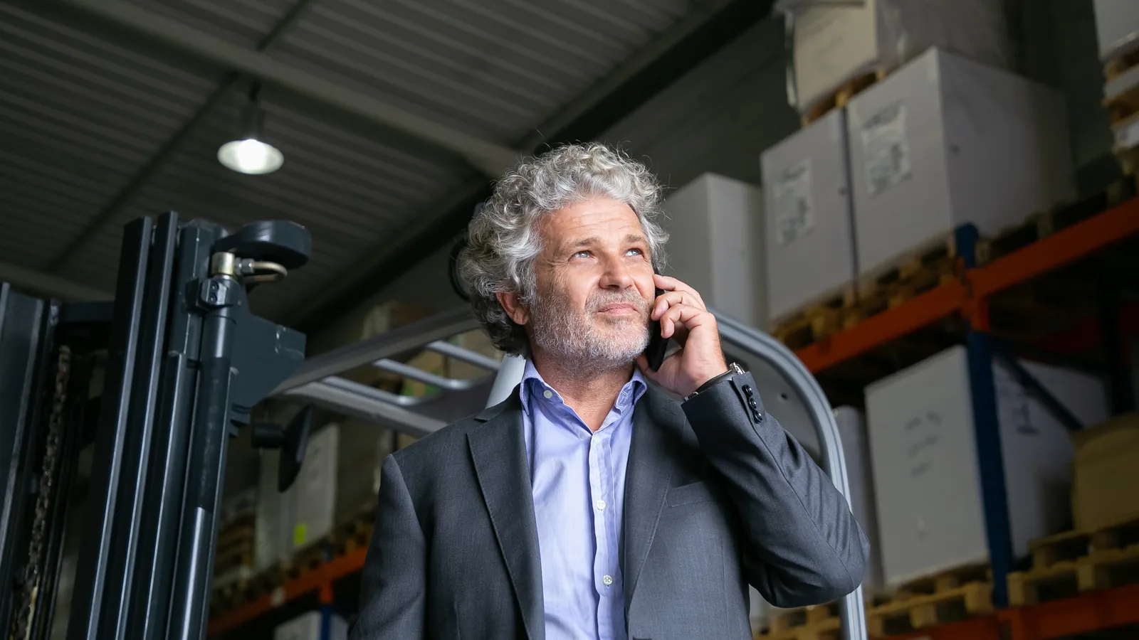 Un chef d'entreprise au téléphone dans son entrepôt
