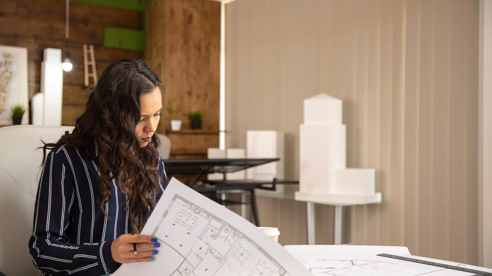 Une architecte examine les plans d'un projet dans son atelier